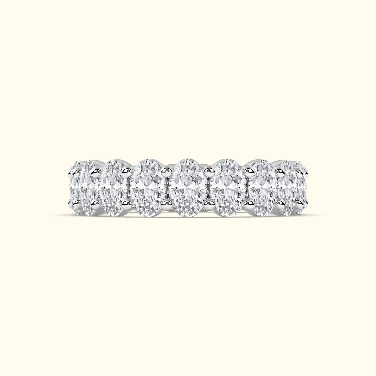 Elegant diamond band featuring multiple oval cut diamonds set in a sleek metal setting.