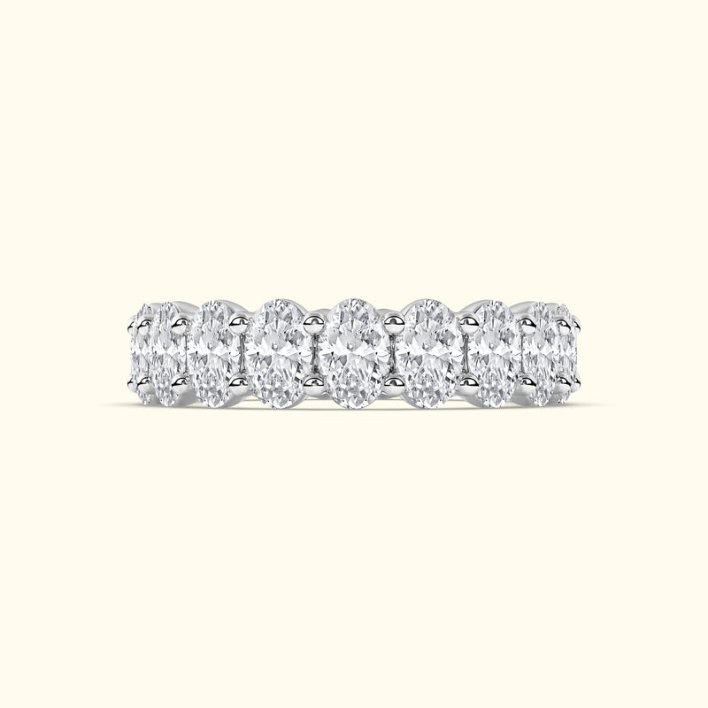 Elegant diamond band featuring multiple oval cut diamonds set in a sleek metal setting.