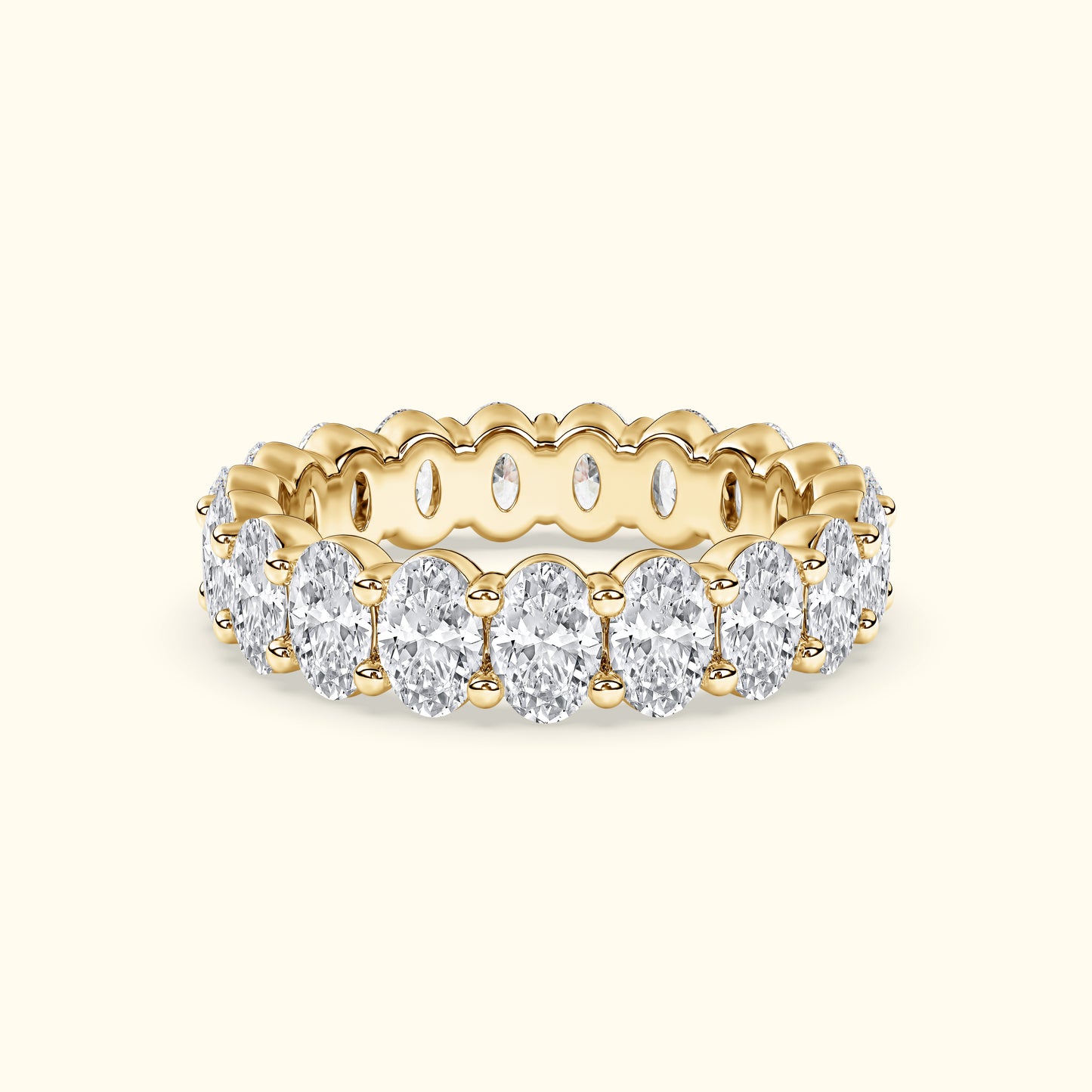 Gold band ring adorned with oval diamonds, featuring a scalloped edge design.