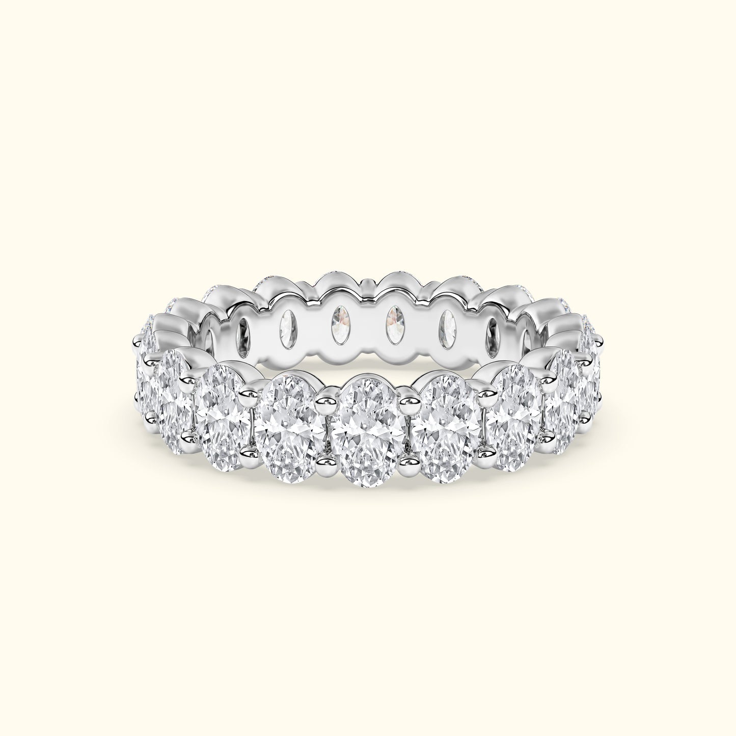 Elegant white gold band adorned with oval-shaped diamonds, featuring intricate detailing.