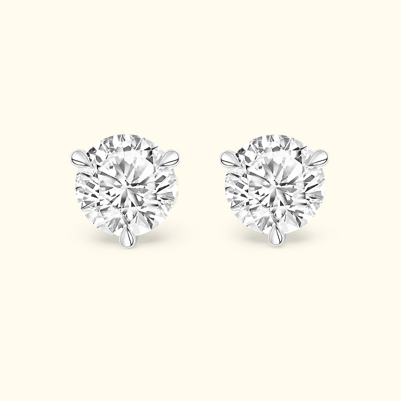 Brilliant diamond stud earrings with a four-prong setting on a light background.