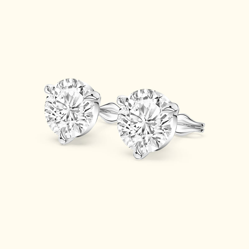 Two sparkling round diamond stud earrings set in a sleek white gold design.