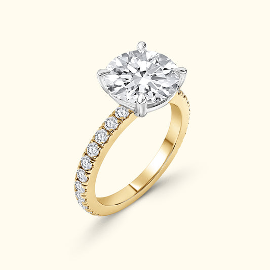 Elegant gold ring featuring a large round diamond set in a silver prong, with smaller diamonds on the band.