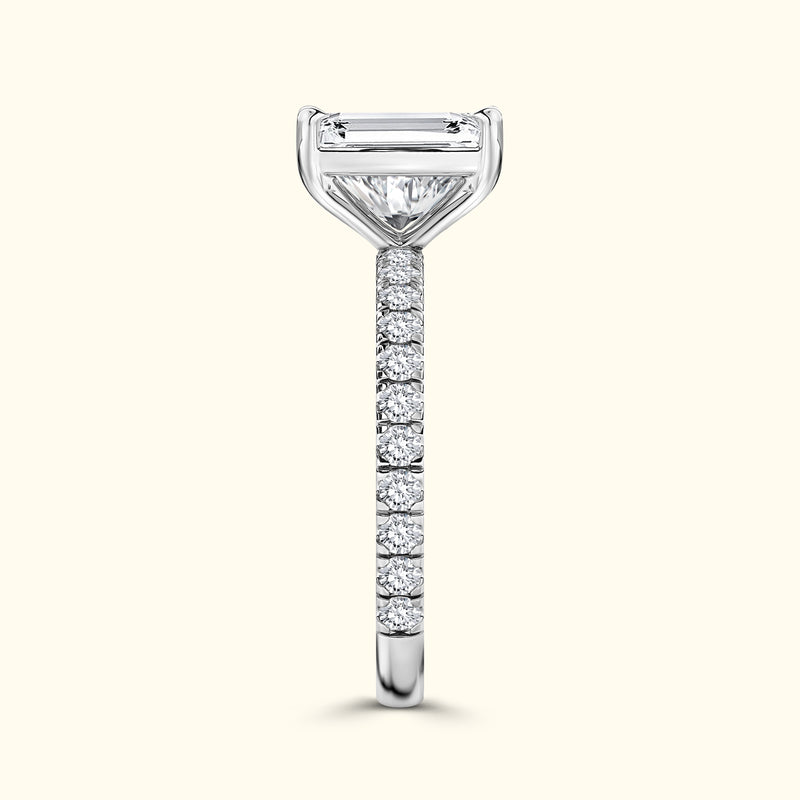 Elegant diamond ring with a central emerald-cut stone and a pave-set band.