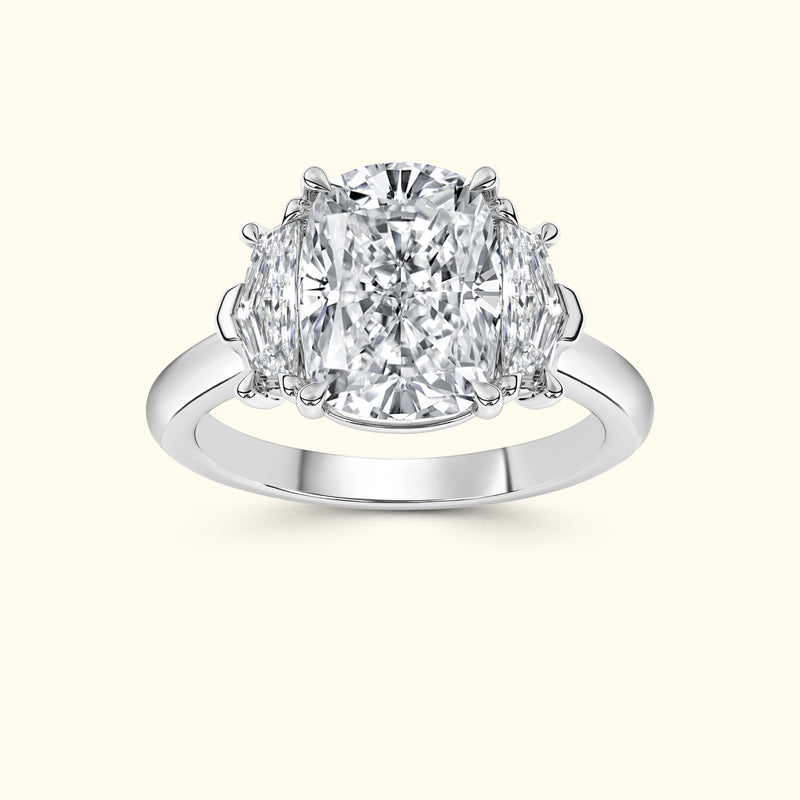 Three-stone diamond ring featuring a large center stone and two smaller side stones.