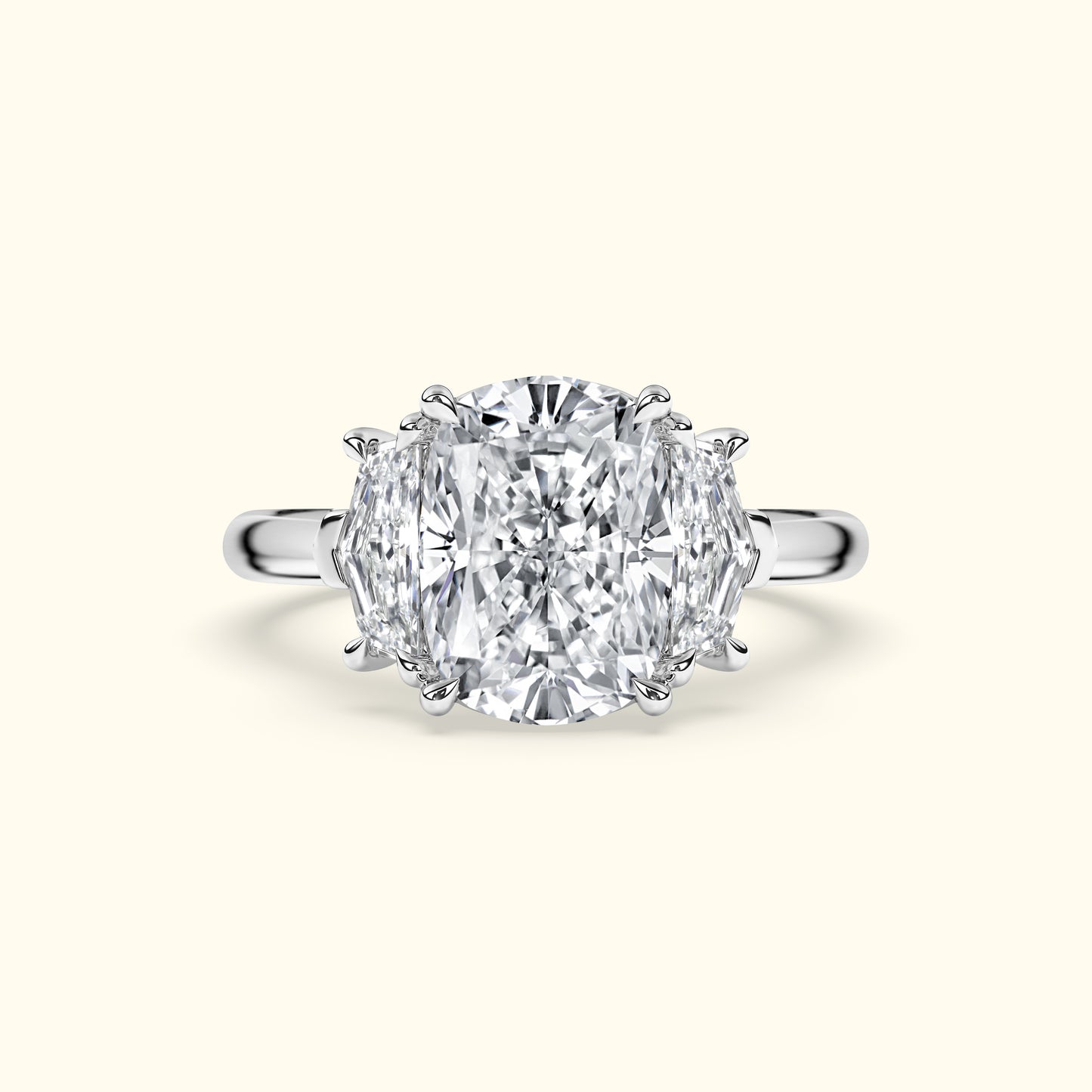 Three-stone diamond ring with a central large rectangular diamond and two smaller side diamonds.