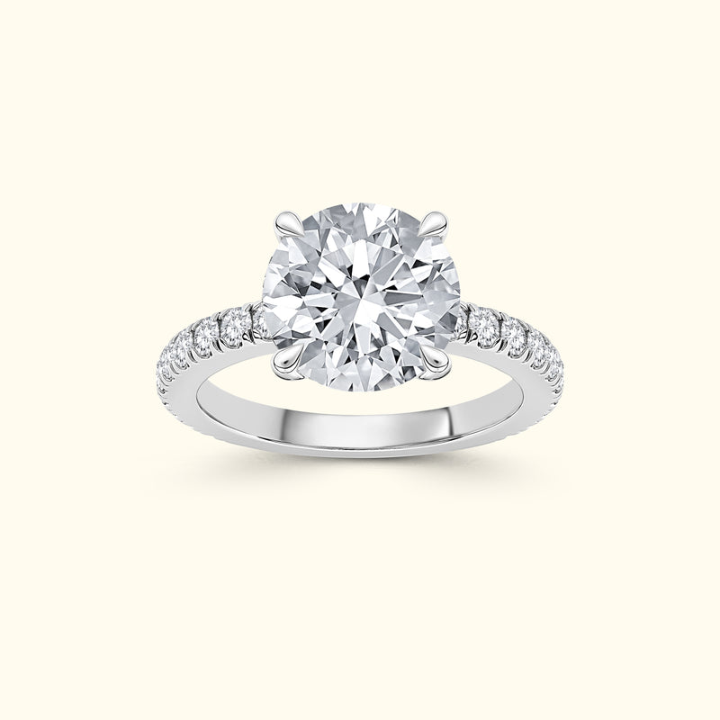 A solitaire diamond ring with a round center stone and smaller diamonds on the band.