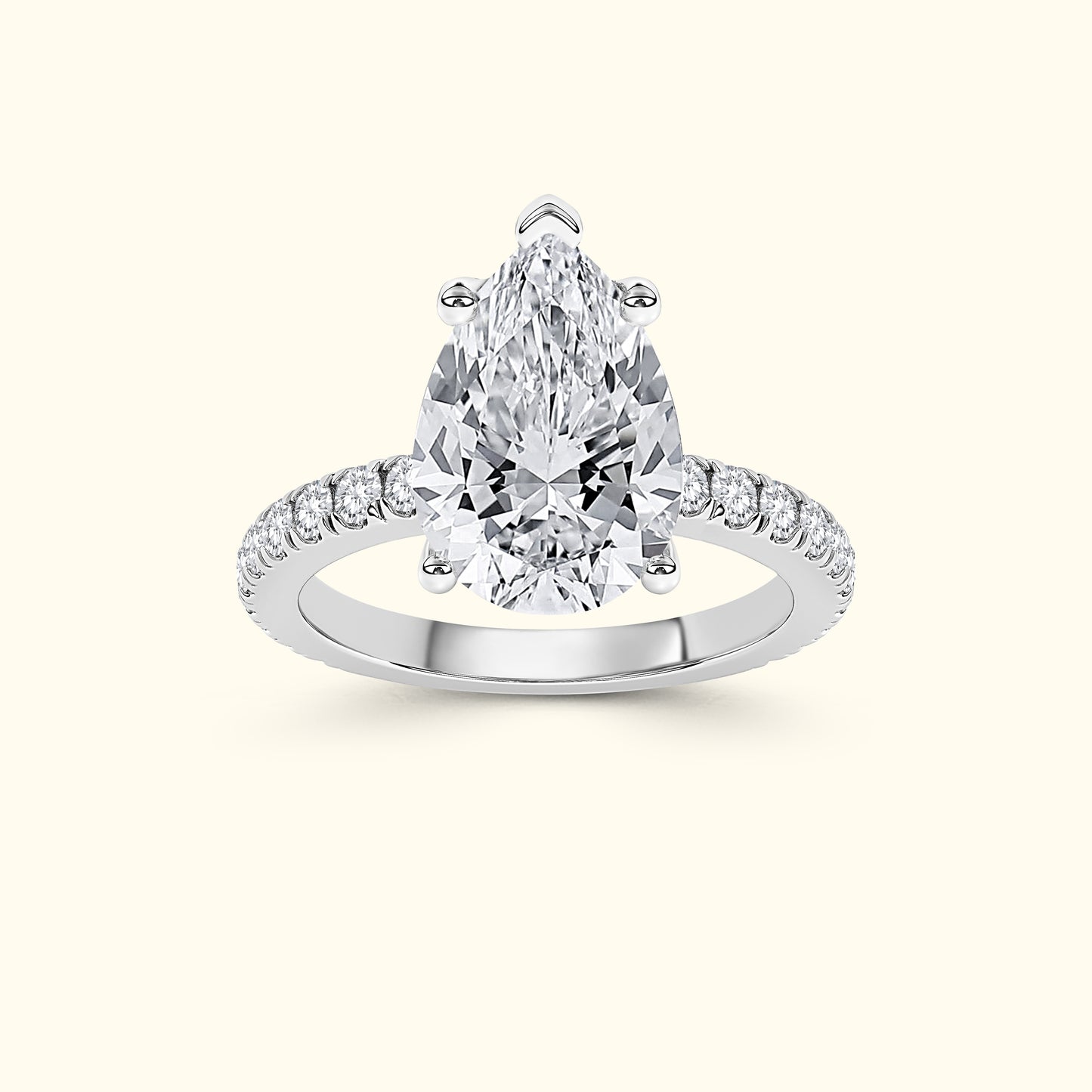 Teardrop diamond ring with a shining band and smaller diamonds along the sides.