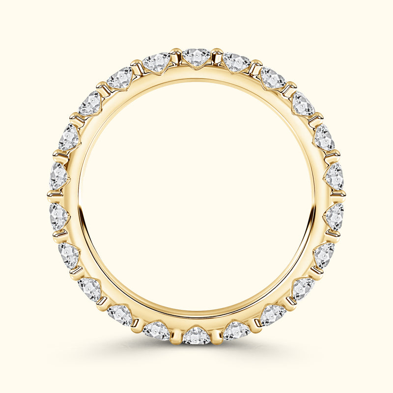 Gold ring with pear-shaped diamonds around the band against a light background.