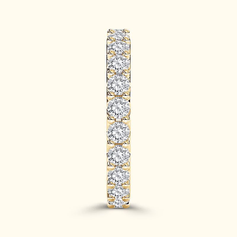 A gold band ring adorned with alternating round diamonds, elegantly shimmering.