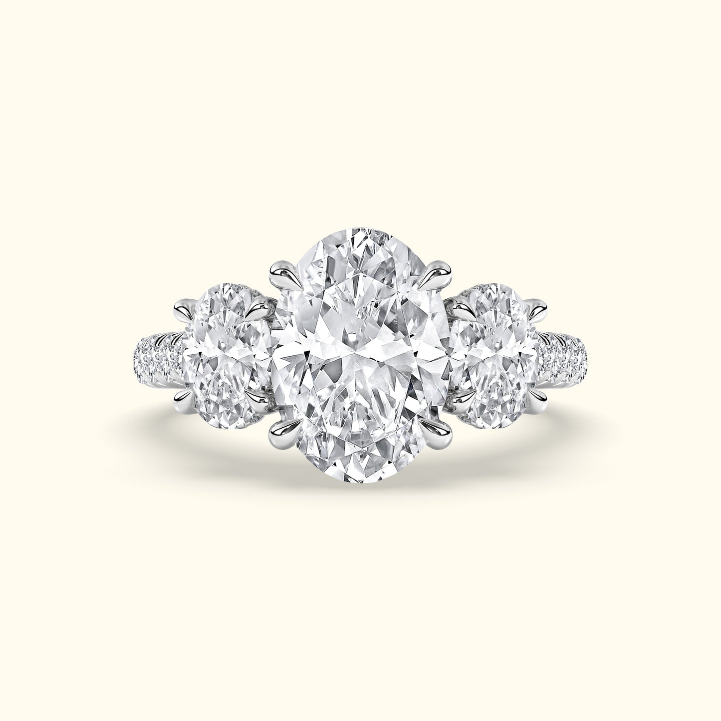 Three-stone diamond ring featuring an oval center stone and two round side stones.