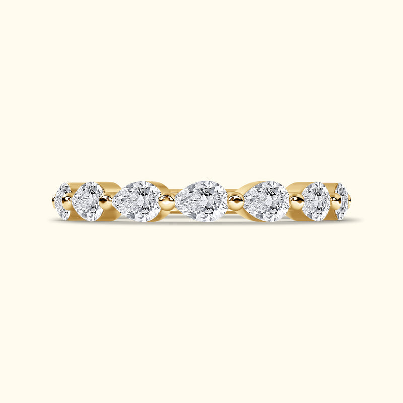 Gold band ring set with alternating pear and round diamonds.