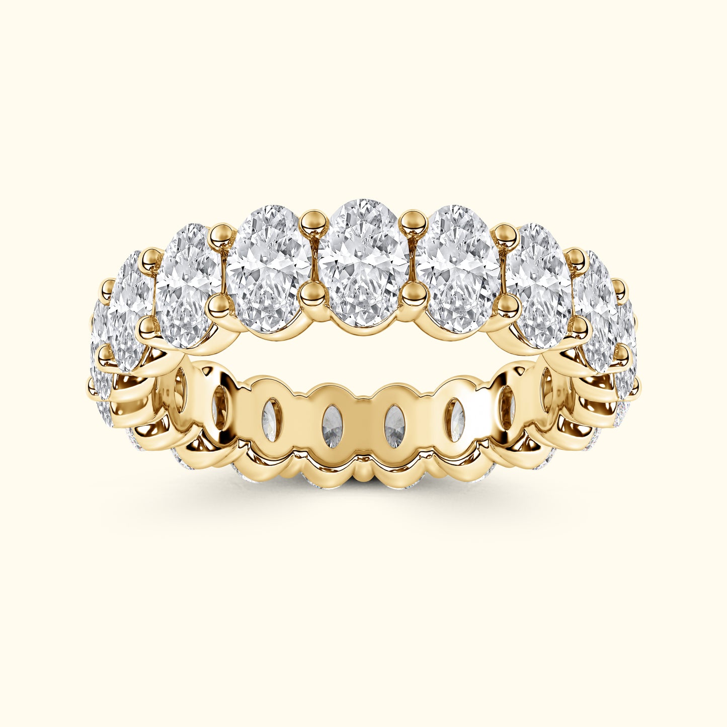 Gold band ring set with multiple oval-shaped, sparkling clear gemstones.
