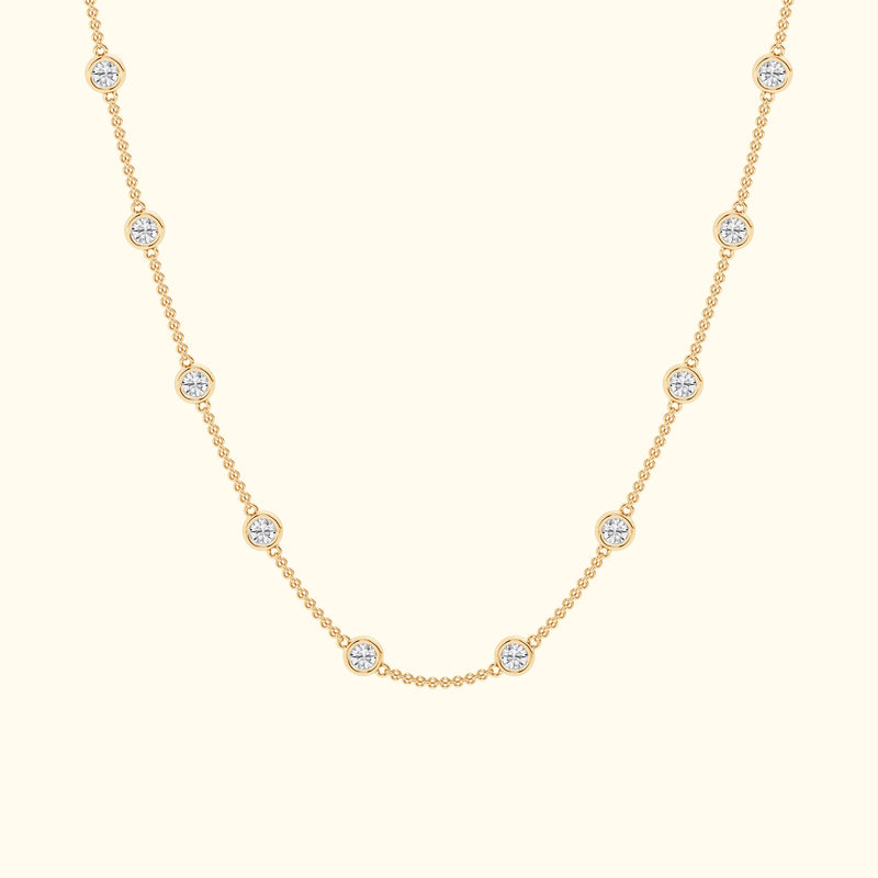 Delicate gold necklace featuring evenly spaced circular diamond accents.