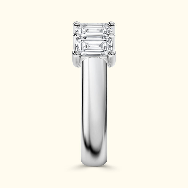 Three-stone diamond ring with a sleek silver band, reflecting light beautifully.