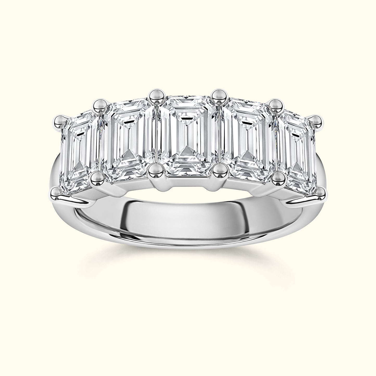 An elegant silver band ring adorned with five emerald-cut diamonds.
