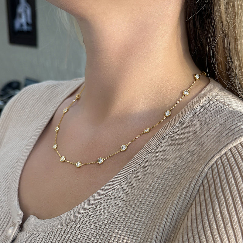 Gold necklace with alternating round gemstones, worn elegantly around the neck.