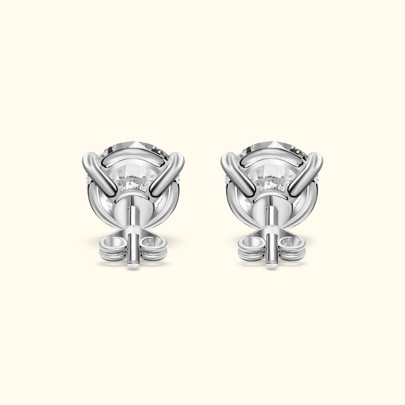 Silver stud earrings with intricate knot designs surrounding clear gemstones.