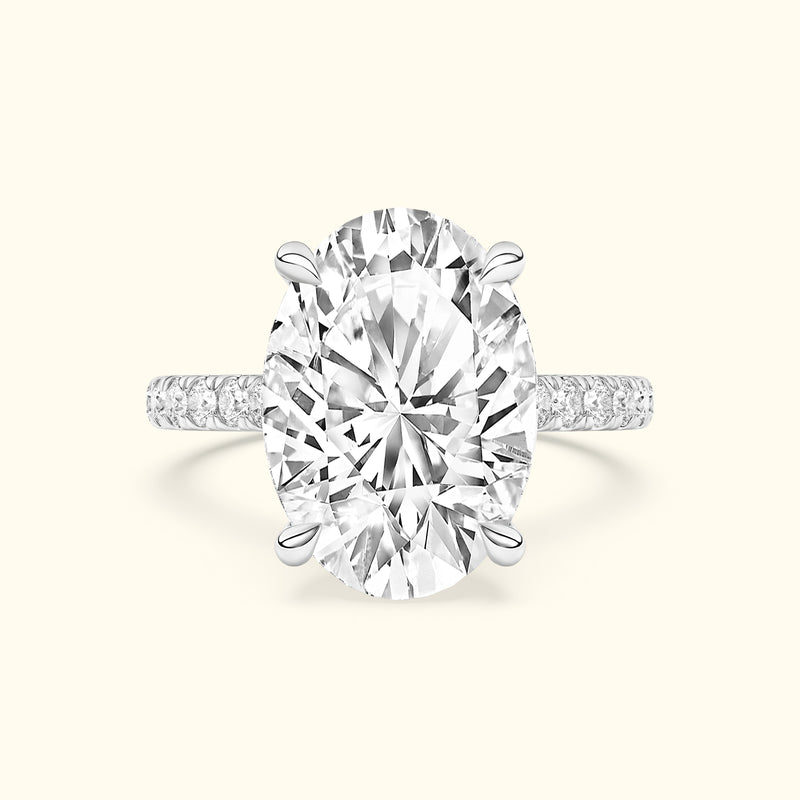 Oval diamond ring with a silver band and smaller diamonds on the shank.
