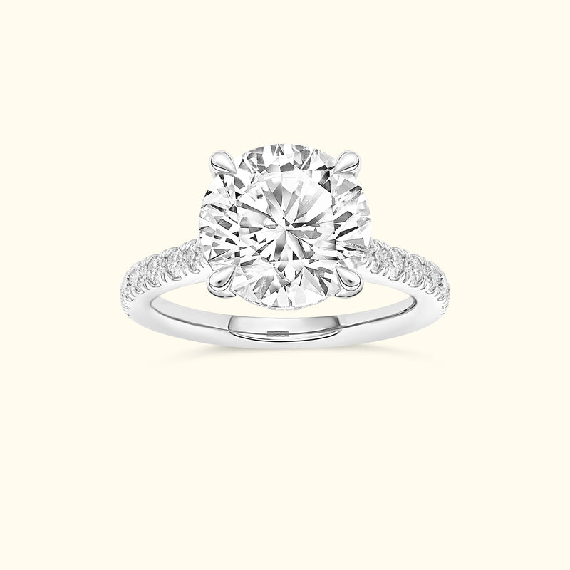 Round diamond engagement ring with a delicate band and sparkling accents.