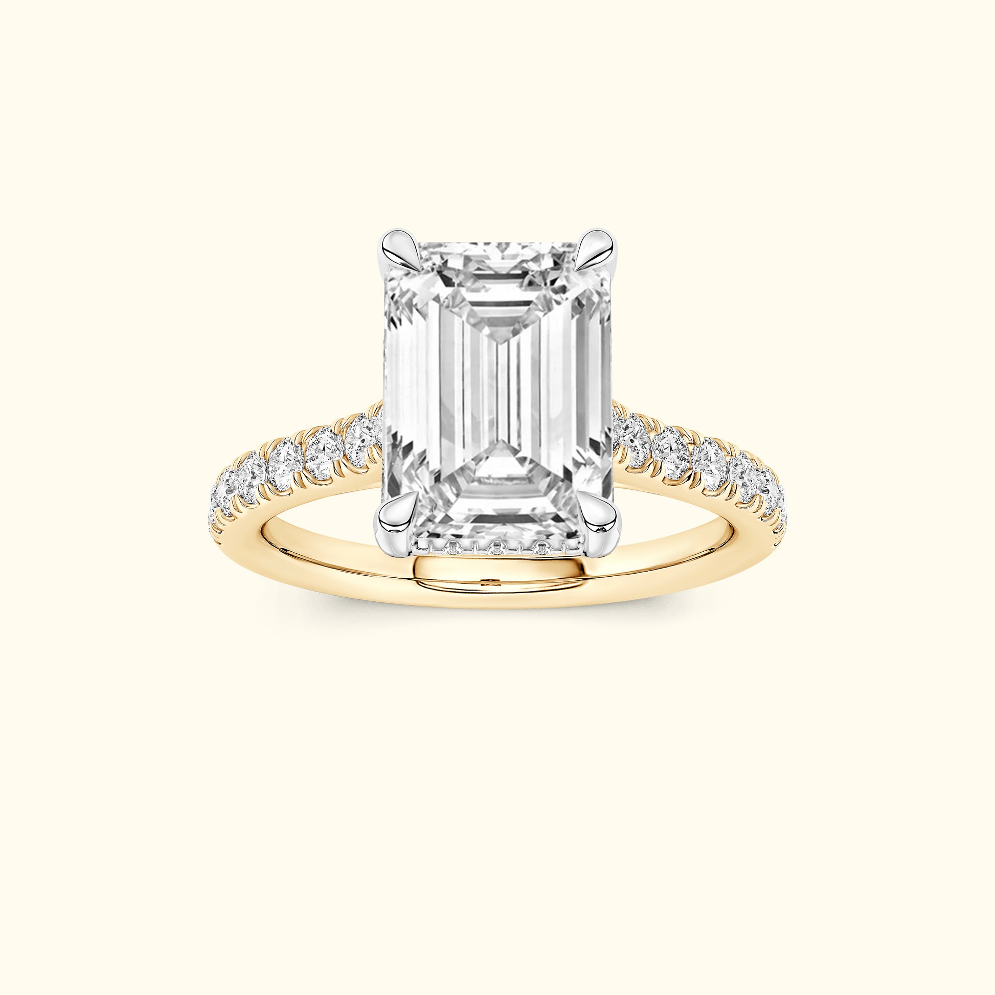 Emerald-cut diamond ring with a yellow gold band and small diamond accents.