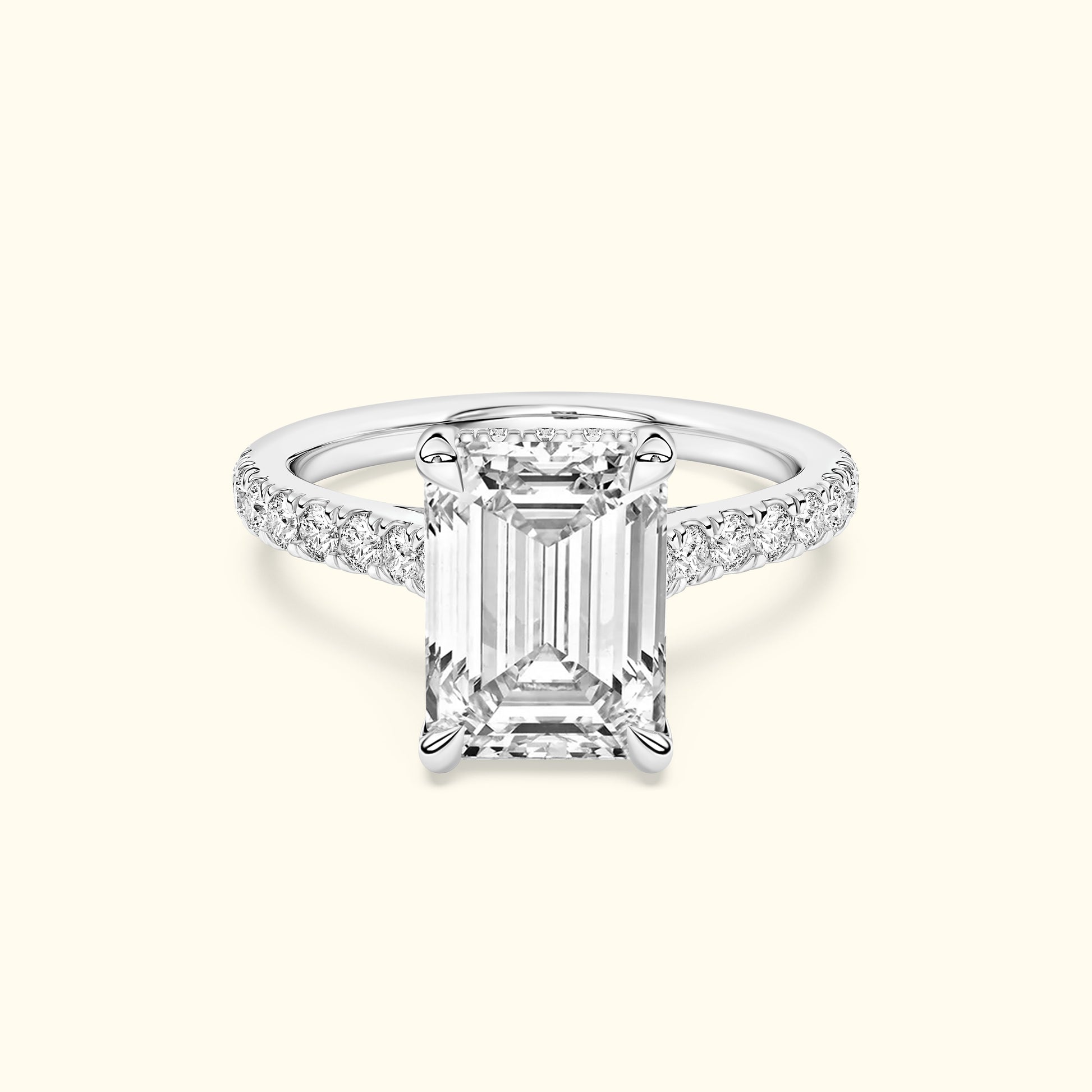 Emerald-cut diamond ring with a sparkling band, set against a light background.