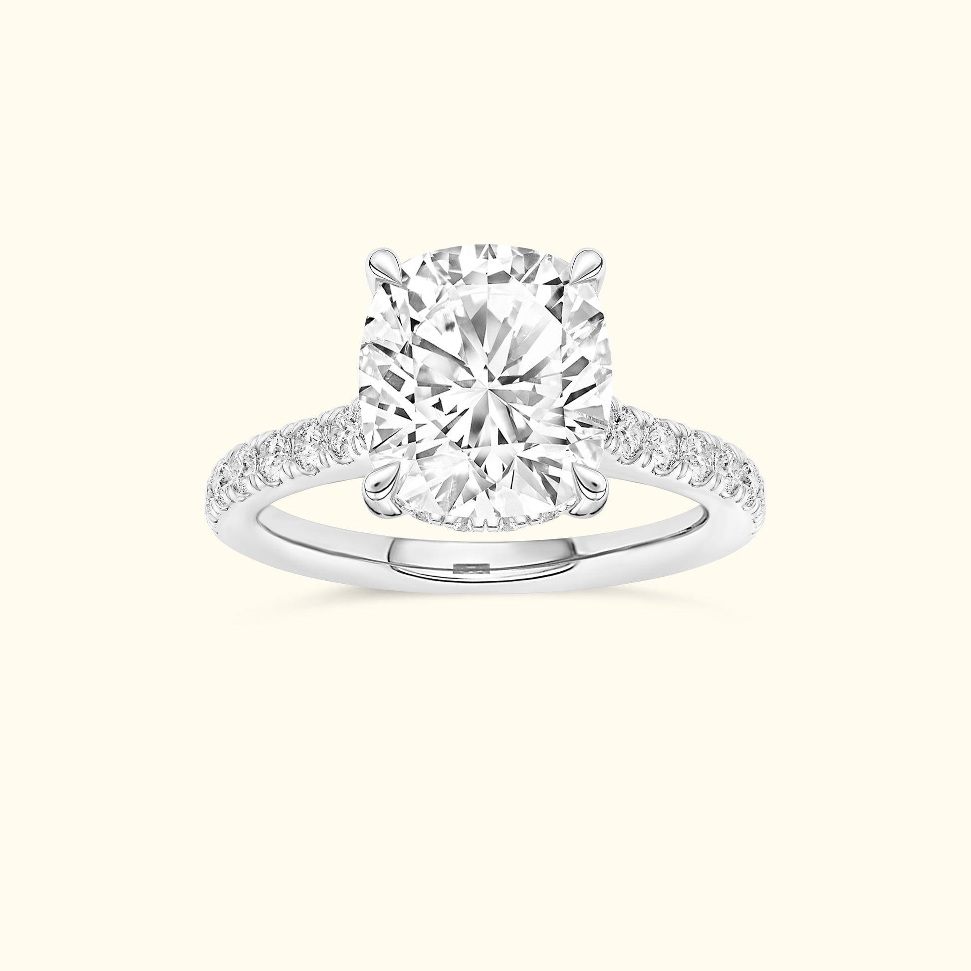 Cushion-cut diamond ring set in a white gold band, adorned with smaller diamonds.