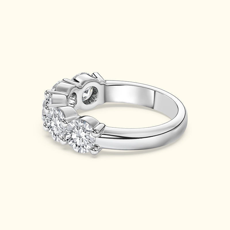 Three-stone diamond ring with a polished silver band.