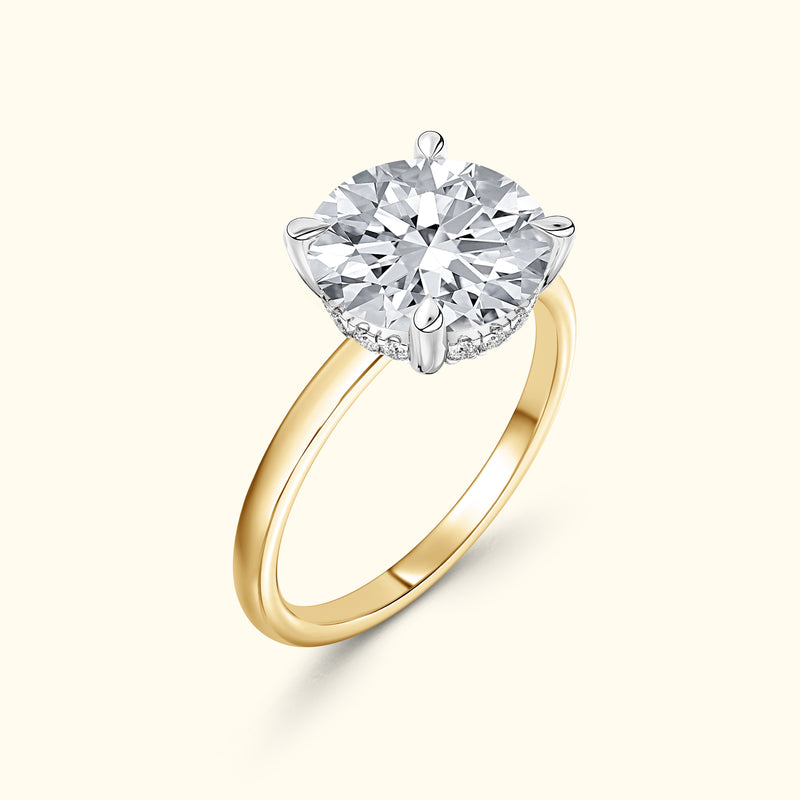 Gold ring featuring a large round diamond set in a silver prong basket.