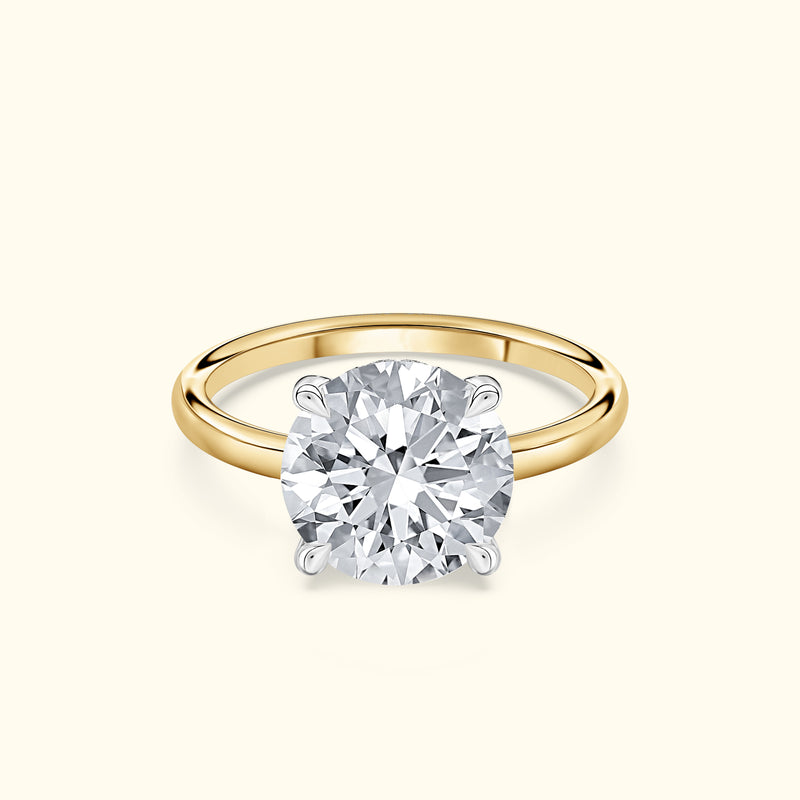 Classic solitaire diamond ring with a round diamond set on a yellow gold band.