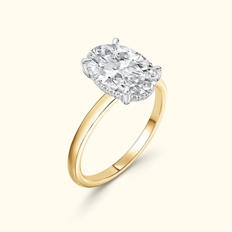 Gold ring with a large oval diamond set in a silver prong setting.