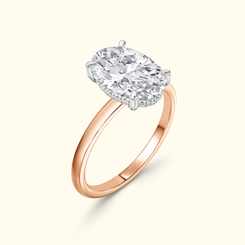 Rose gold ring featuring a large oval diamond with a silver setting.