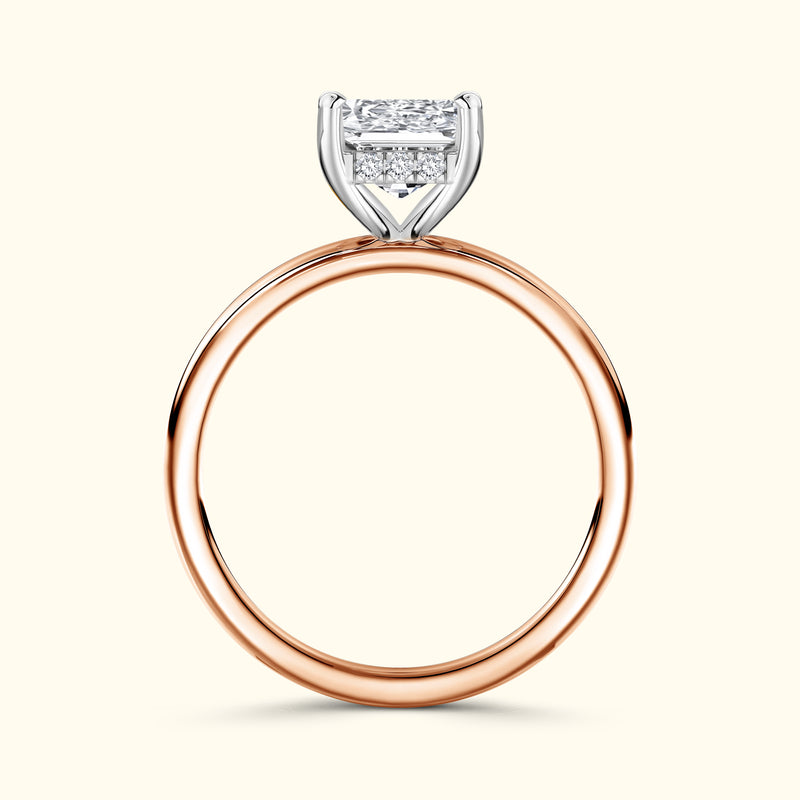 A rose gold engagement ring featuring a rectangular diamond center stone and side stones.