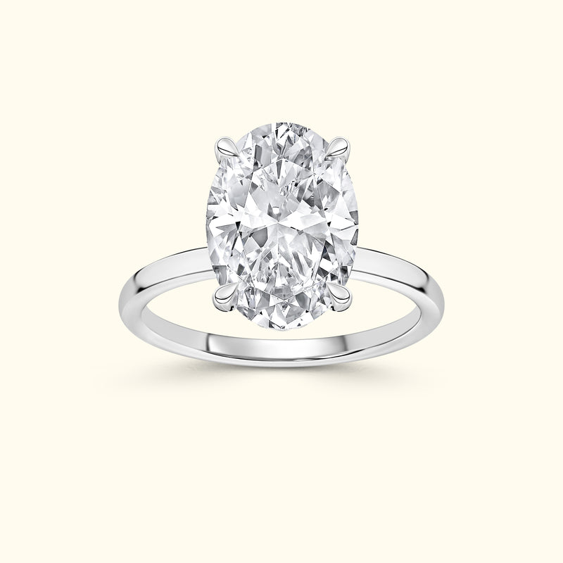 Oval diamond ring set in a simple silver band against a light background.