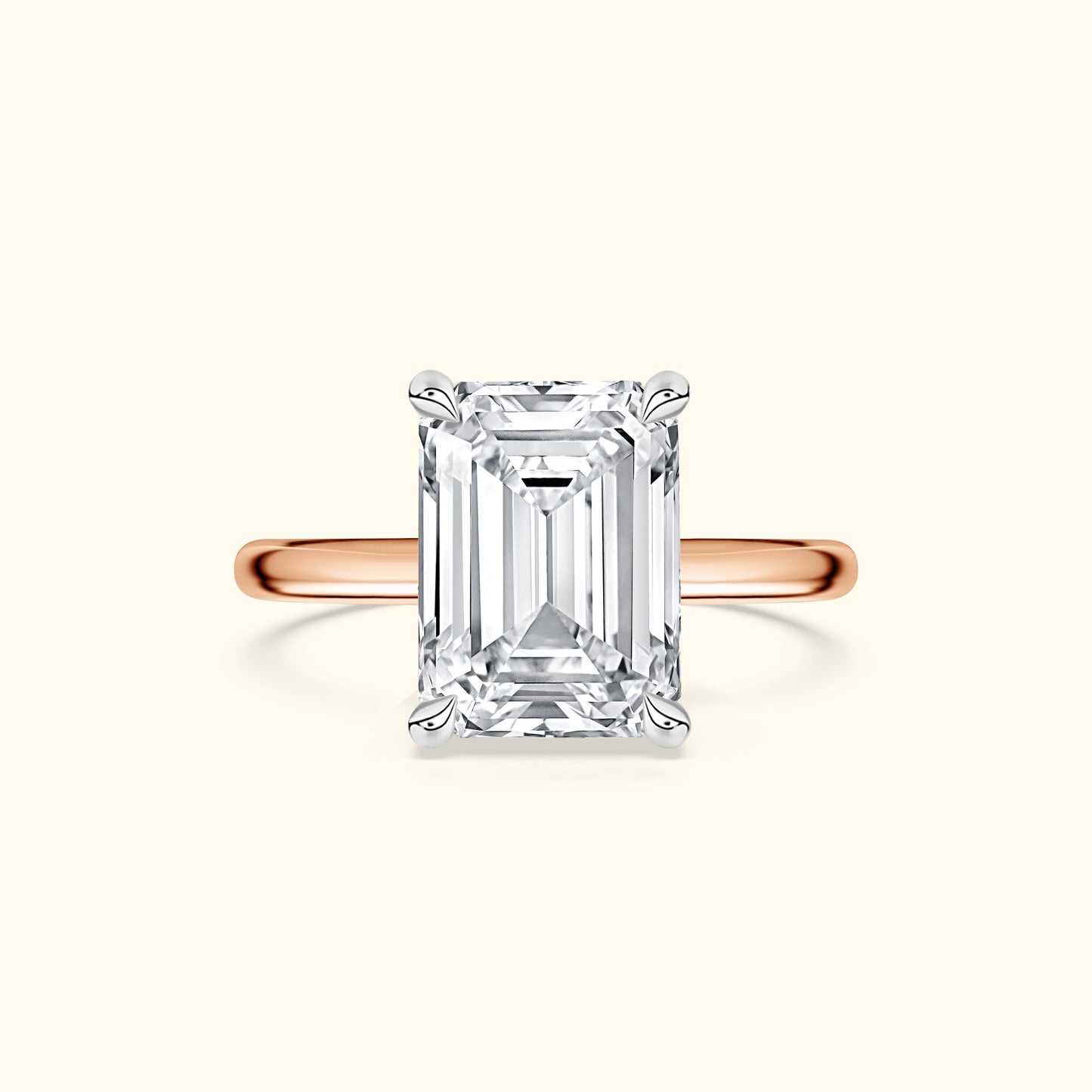 Emerald-cut diamond ring set on a rose gold band against a light background.