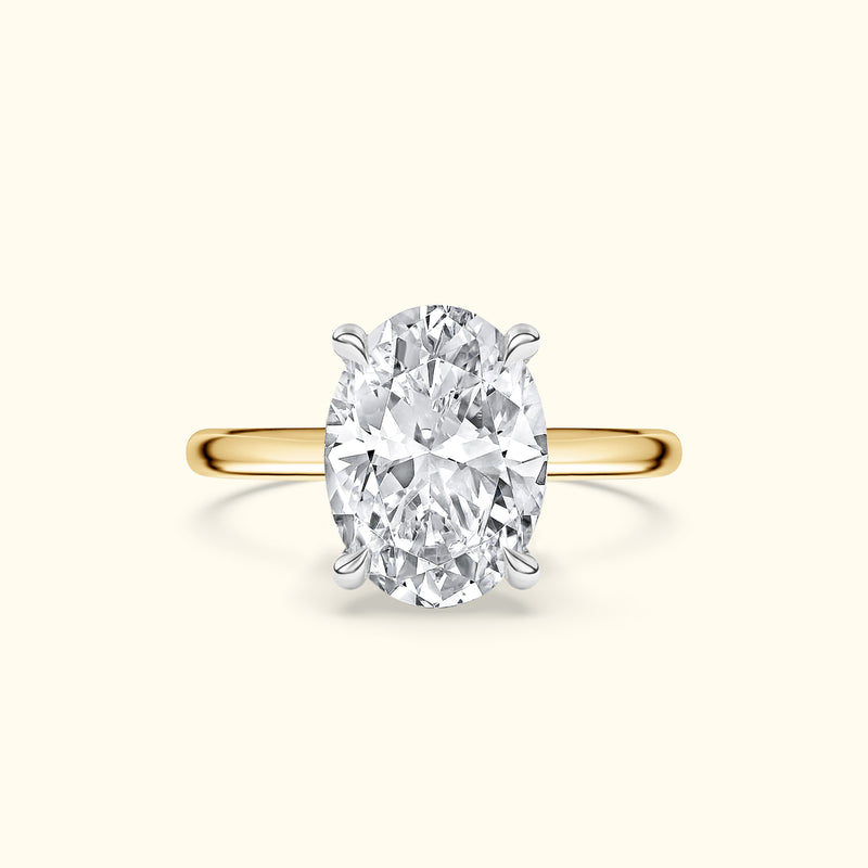 Gold ring featuring a large oval diamond set in a silver prong setting.