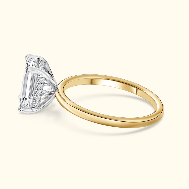 Elegant two-tone engagement ring featuring a prominent emerald-cut diamond centerpiece.