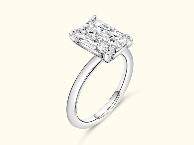 Diamond engagement ring with a rectangular cut stone set in a sleek silver band.