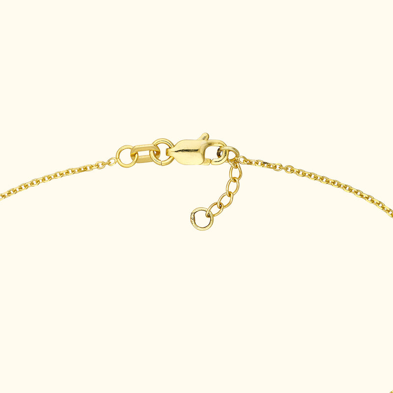 Close-up of a gold chain bracelet with a lobster clasp and adjustable links.