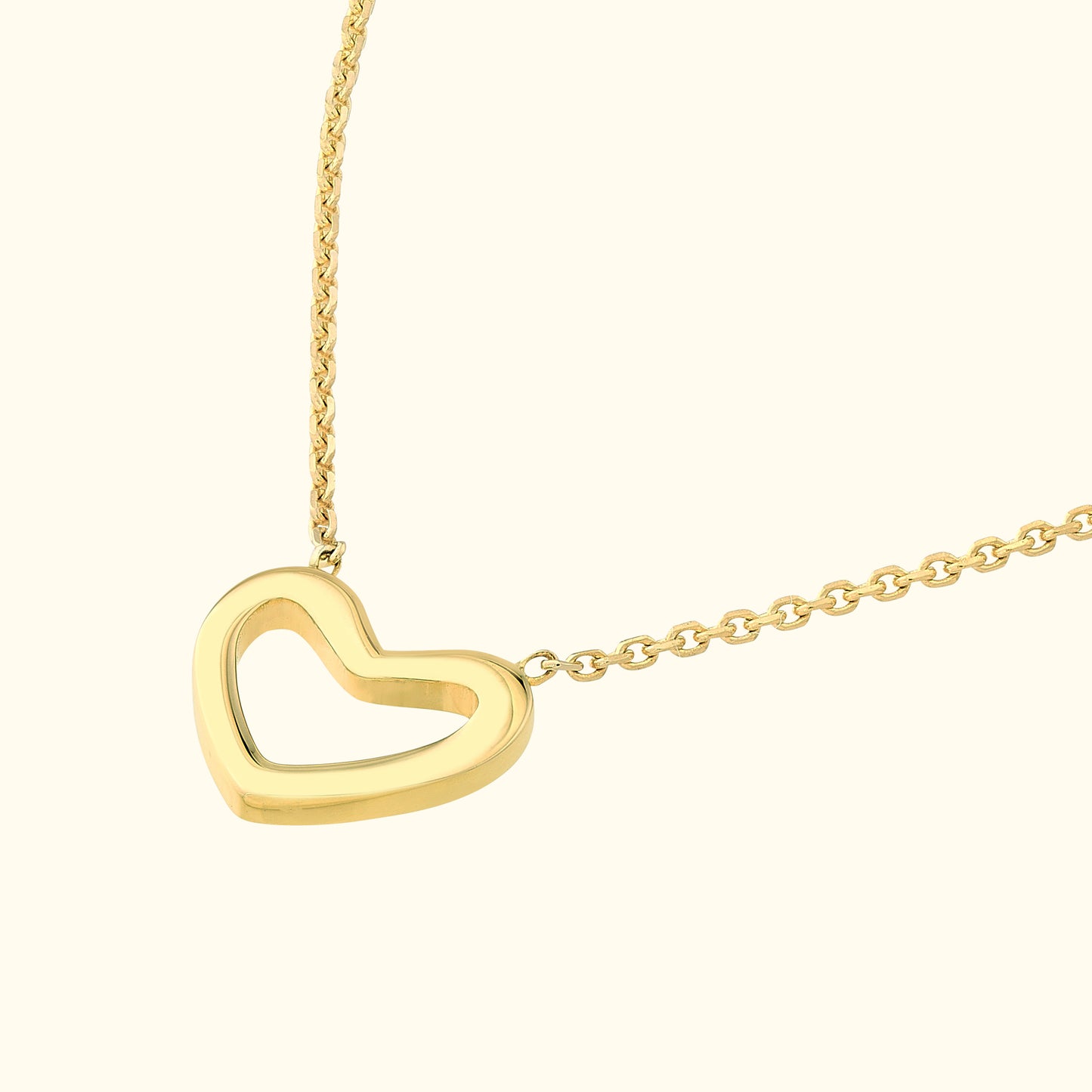 Gold heart necklace on a delicate chain with a hollow center.