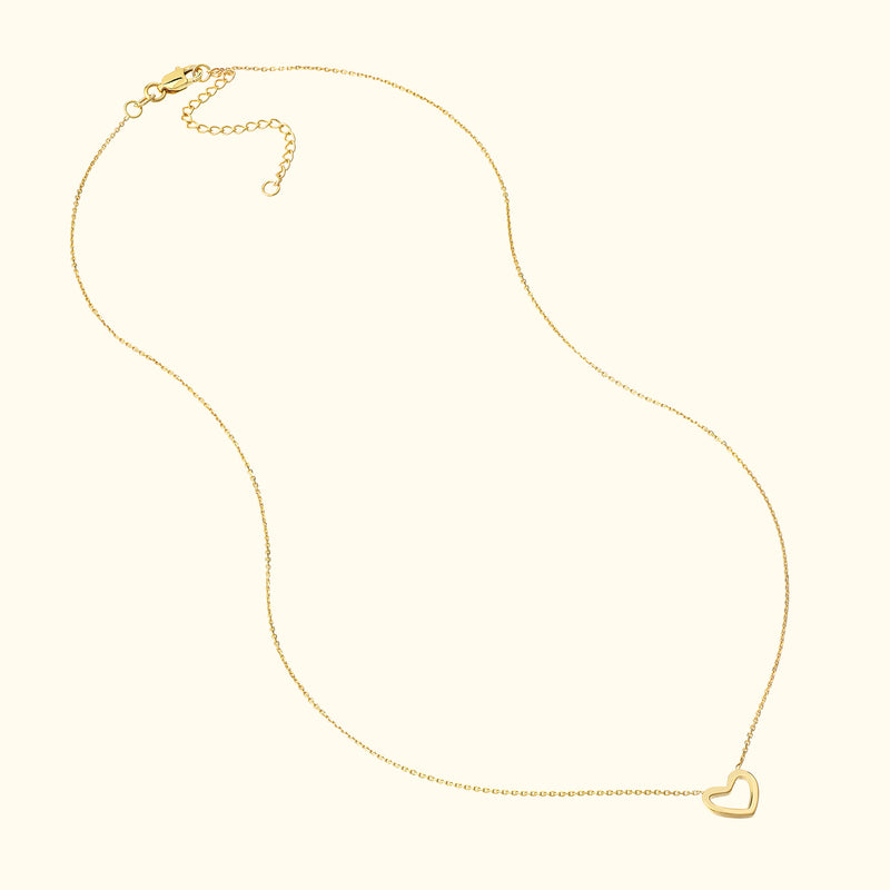 Delicate gold necklace with a small heart pendant.