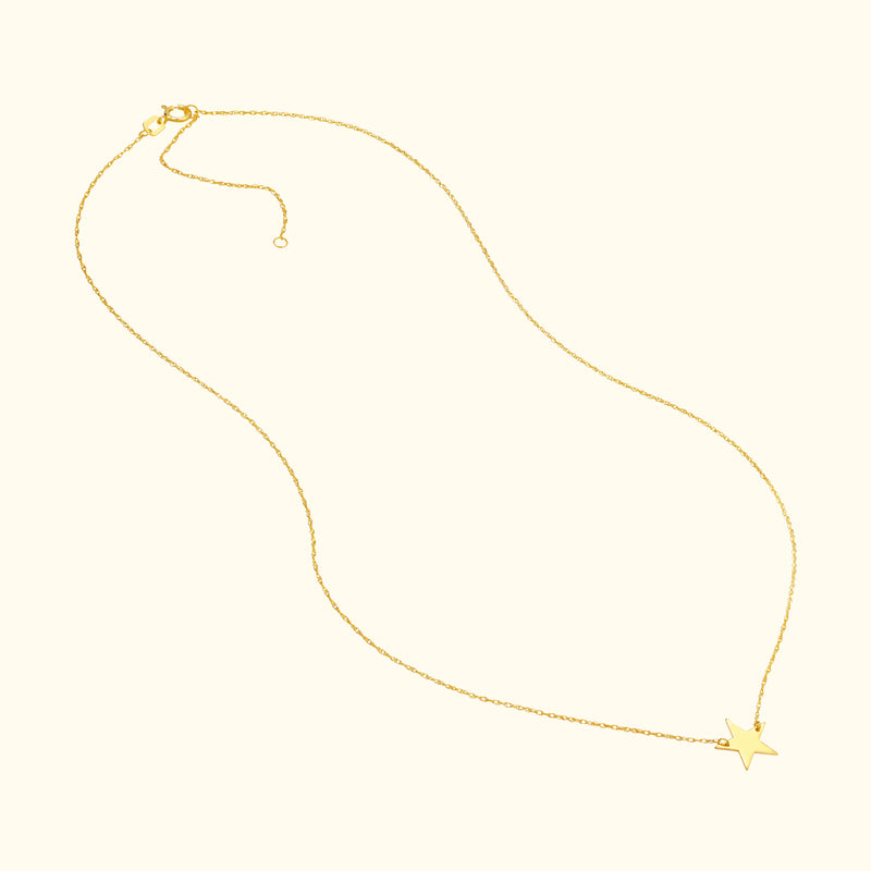 Delicate gold necklace with a star pendant hanging at the center.