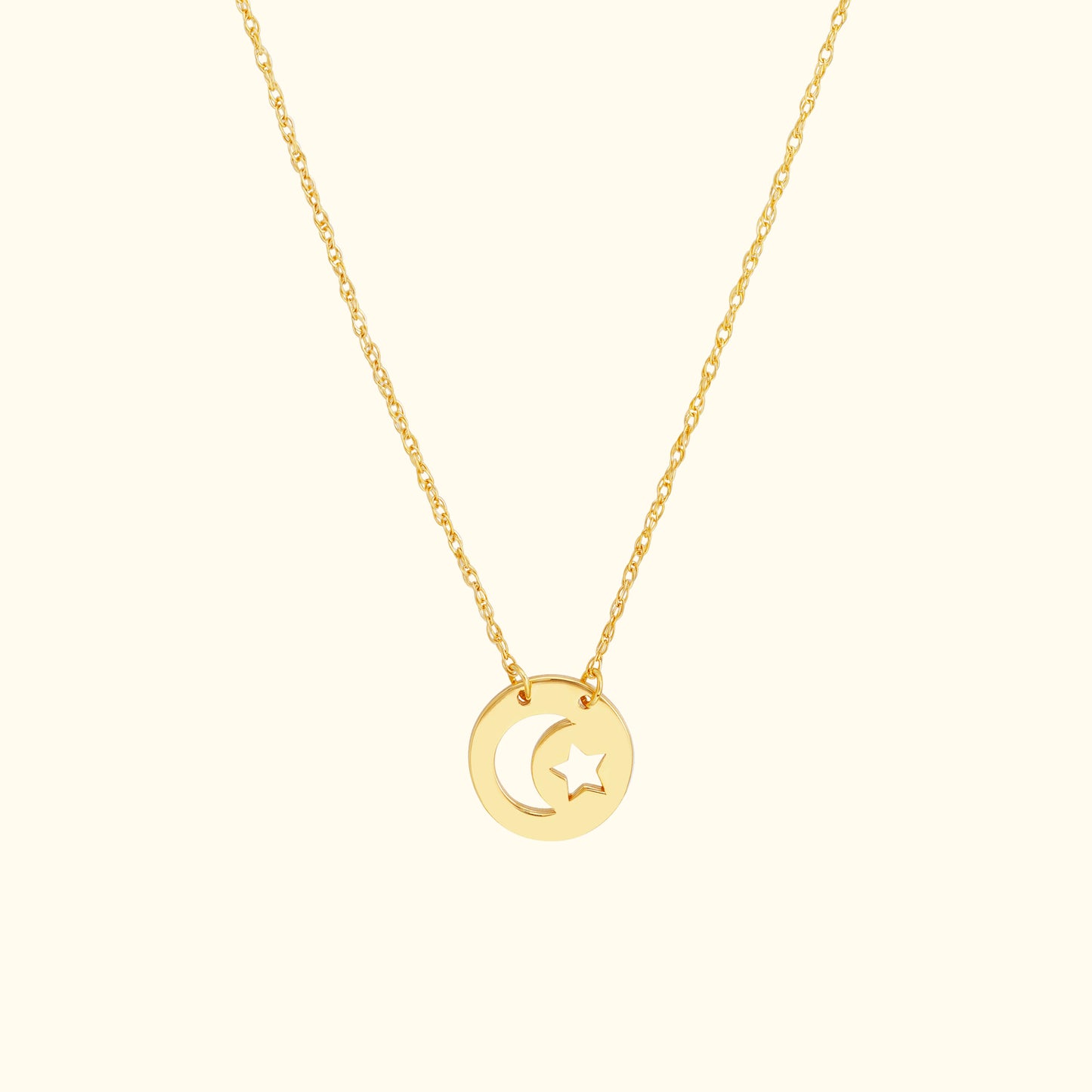 Gold necklace featuring a circular pendant with a moon and star design.