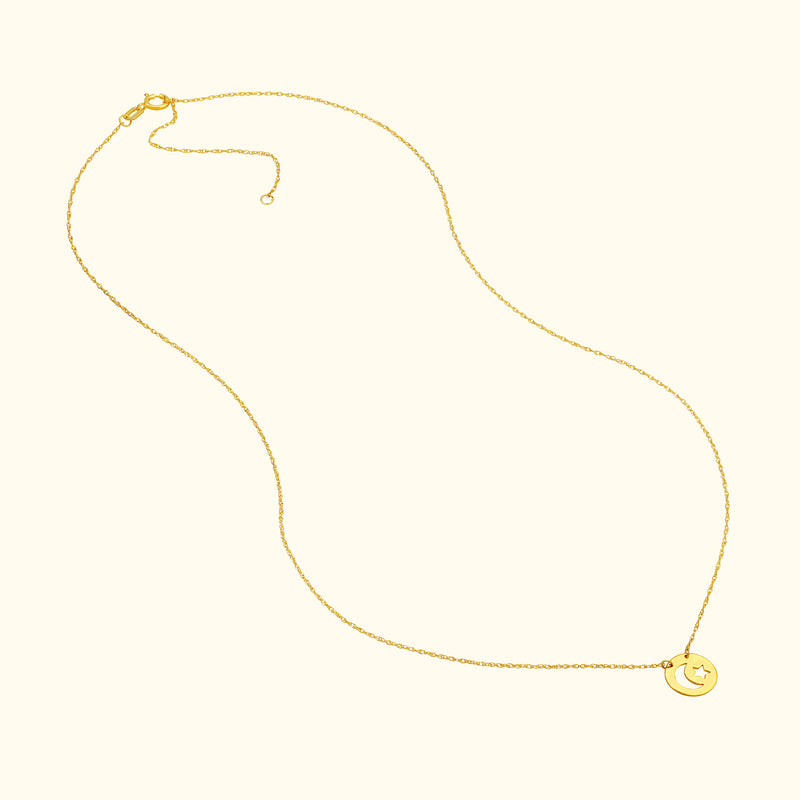 Delicate gold necklace with a smiling moon pendant on a soft, neutral background.