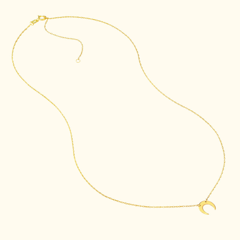 Delicate gold necklace featuring a crescent moon pendant.