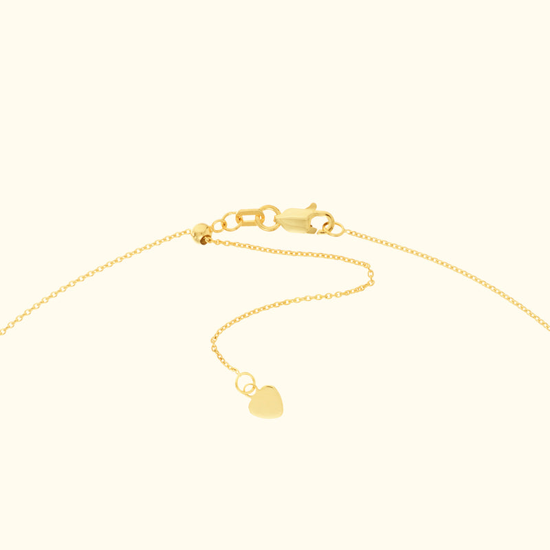 Delicate gold chain necklace with a small heart pendant.