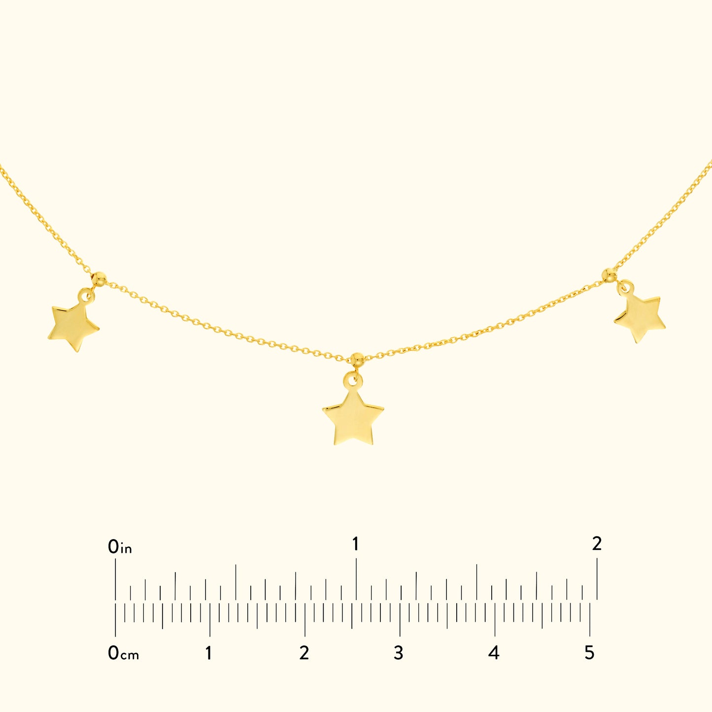 Gold star pendant necklace featuring three star charms on a delicate chain.