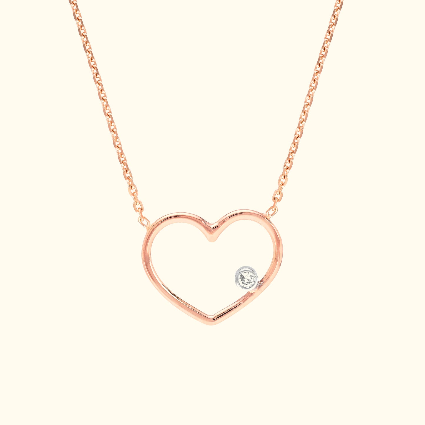 Rose gold heart necklace featuring a small diamond accent.