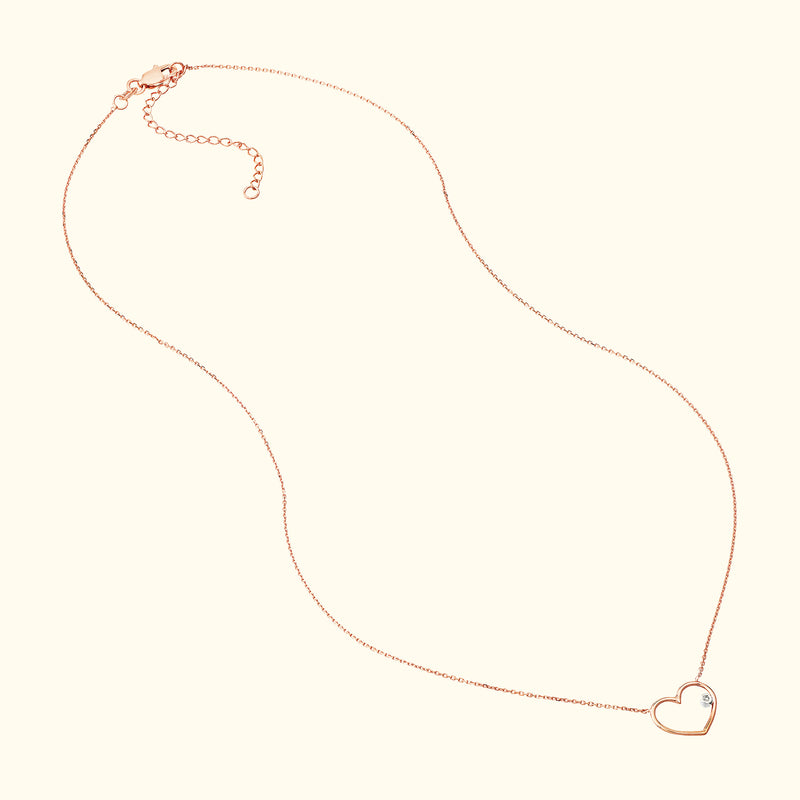 Delicate rose gold heart necklace with a small diamond accent.