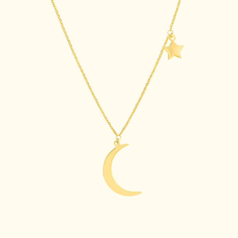 Gold necklace featuring a crescent moon and a small star charm.